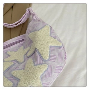 Détail du sac en toile tissée violette avec étoiles en peluche blanches et fermeture