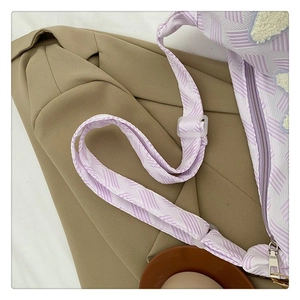 Détail du sac en toile à rayures mauves avec patch étoile et boucle de bandoulière