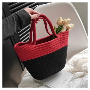 Detail of red and black woven bucket bag with spiral texture and cotton rope handle