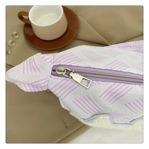 Détail macro du sac tressé violet avec bordure sherpa blanche et zip métallique