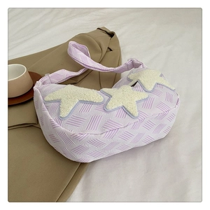 Détail du sac bandoulière tissé violet clair avec trois étoiles douces blanches sur le devant