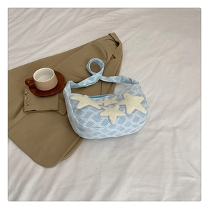 Détail du sac bleu avec appliques d'étoiles sur un fond en tissu naturel