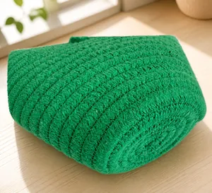 Gros plan du sac en paille verte montrant la texture détaillée du tricot en spirale