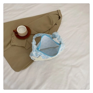Détail du sac bandoulière en toile à rayures bleues avec une étoile en peluche blanche