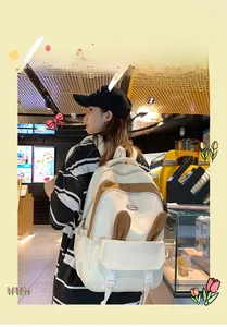 Rear view of cute cream and brown backpack with plush bunny ears on a female model