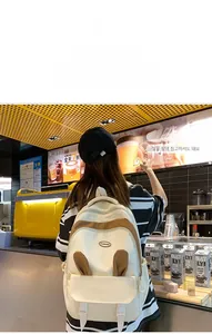 Detailed view of the cute cream school bag with plush rabbit ears worn by a model