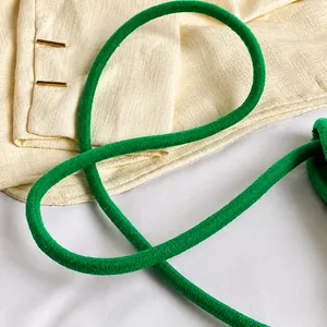 Détail de la bandoulière tressée verte avec une texture tissée en spirale raffinée