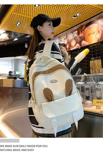 Girl wearing a cute white backpack with rabbit ears and brown accents in a casual setting