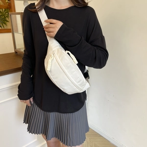 Minimalist off-white nylon chest bag with thick rope zipper and wide woven strap for women