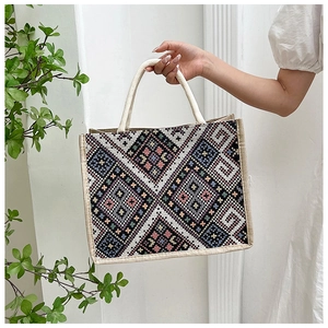 Dettaglio della trama geometrica a rombi e del manico in corda della borsa tote