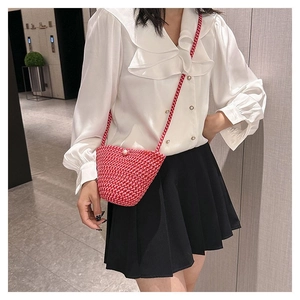 Détail du mini sac crocheté rouge et blanc avec fermoir perle et bandoulière