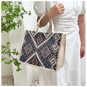Dettaglio della borsa tote in tela etnica con motivi geometrici intrecciati