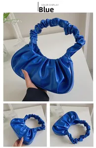 Detail of royal blue pleated cloud bag showing matte PU leather and ruched handle texture