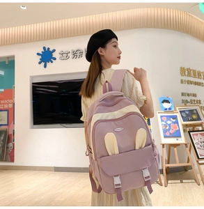 Mauve cute backpack with rabbit ears shown by a model in an art gallery setting