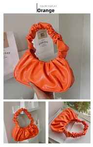 Detail view of orange pleated cloud bag with soft PU leather handle and interior storage