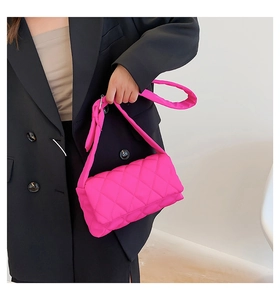 Détail du sac oreiller en nylon matelassé fuchsia avec bandoulière large rembourrée