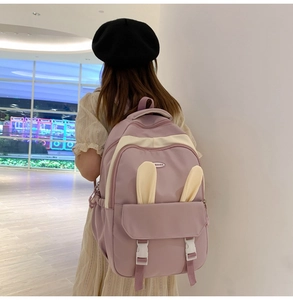 Detail of purple backpack with bunny ears showing back view on model in a shopping mall