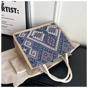 Dettaglio della grande borsa tote con motivi geometrici tessuti e manici in corda