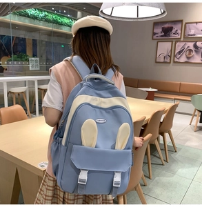 Detail of light blue and white school backpack featuring cute 3D bunny ears and front buckle