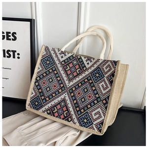 Dettaglio borsa tote in iuta tessuta con motivo geometrico retrò e manici resistenti