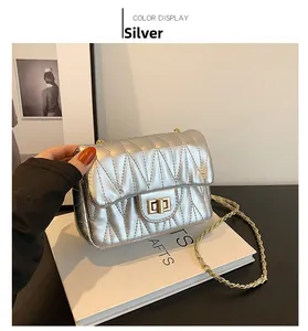 Detail of silver quilted shoulder bag with V-shaped stitching and golden twist lock