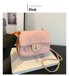 Detailed view of pink quilted handbag with gold twist lock and chain strap for women