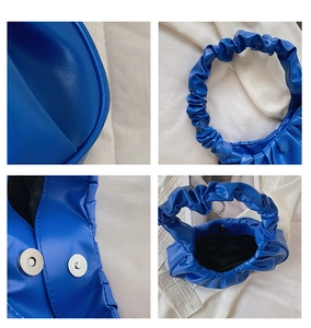 Detail view of royal blue cloud bag showing pleated handle, PU leather texture and magnetic snap