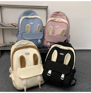 Detail of four colorful backpacks with cute rabbit ears and fashion emblems on display