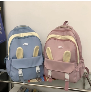 Detail of blue and pink cute backpacks with rabbit ears and buckled front pockets