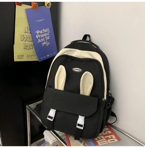Detail showing cute white rabbit ears and buckle closures on black and white nylon backpack
