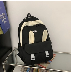 Close-up of black and white canvas backpack featuring cute bunny ears and buckle front pocket