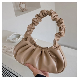 Detailed view of beige cloud bag with pleated soft leather texture and round handle
