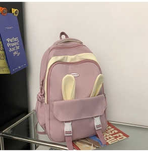Detail of pink backpack with cute bunny ears and fashion label on waterproof nylon fabric