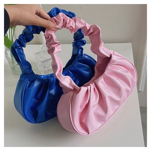 Detail view of ruched PU leather handles on royal blue and light pink shoulder bags