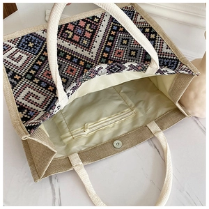 Dettaglio borsa tote geometrica con chiusura magnetica e tasca interna con zip