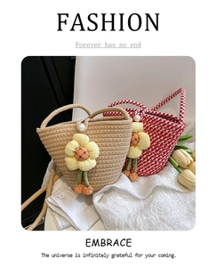 Detail view of woven bucket bags with pearl closures and yellow flower pendants