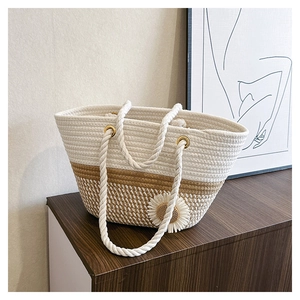 Close-up of woven tote bag with rope handles and decorative sunflower detail