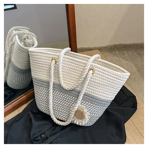 Detail of hand-woven cotton tote bag featuring white and gray patchwork and daisy charm