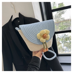 Detalle de bolso de hombro tejido con girasol 3D y correa fina en color azul claro