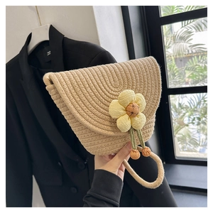 Detalle de bolso de paja tejido a mano con flor amarilla 3D y asa de cuerda de algodón