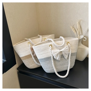 Detail of hand-woven straw tote with mesh bow and sturdy white rope handles