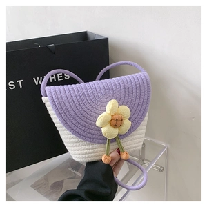 Detalle del bolso tejido morado y blanco con flor 3D y colgante de cuentas naranja