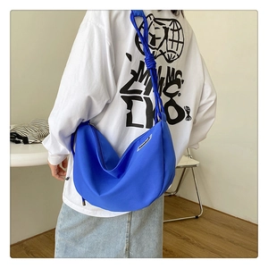 Detail of the electric blue nylon crescent bag featuring a unique knotted shoulder strap