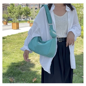 Detail of teal nylon shoulder bag with adjustable strap and mini coin pouch