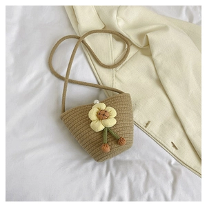 Handwoven khaki bucket bag with yellow floral accent and elegant pearl closure