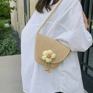 Straw woven flower bucket bag with crossbody strap and floral ornament for summer fashion