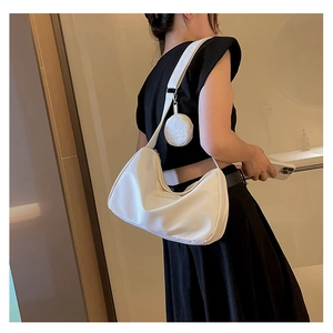 Detail of adjustable strap and round coin pouch on creamy nylon crescent crossbody bag