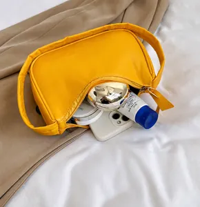 Detailansicht der gelben Hobo-Tasche zeigt Stauraum für Handy und Kosmetikartikel