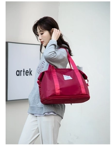 Detalle de bolsa de viaje de nailon burdeos con compartimento para zapatos y asas rosas
