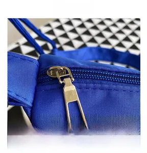 Detail of smooth silver metal zipper and blue nylon fabric on large shoulder bag
